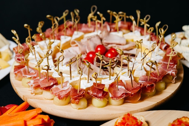 Meloen canapeetjes met prosciutto op spiesjes stukjes brie kaas dunne plakjes vlees en tomaten