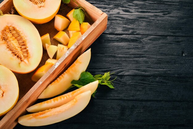 Meloen in een houten kist In stukjes gesneden meloen Op een houten ondergrond Vrije ruimte voor tekst Bovenaanzicht