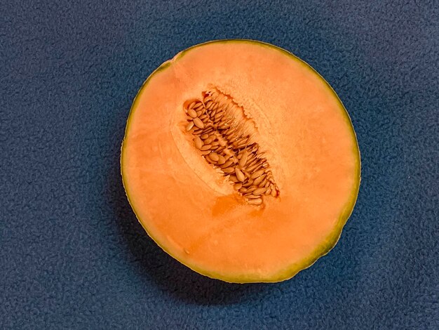 A melon cut in half on a blue background View from above