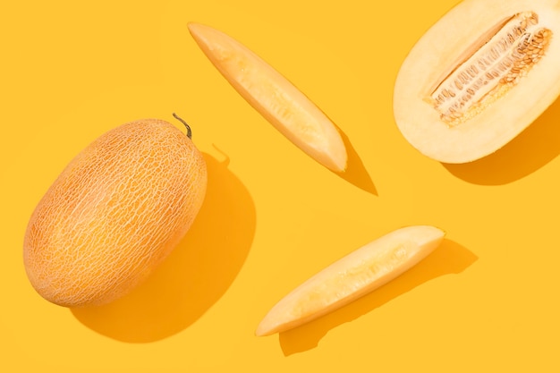 Melon cut into pieces on a yellow background