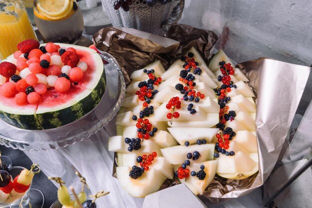 Melon decorated with currants blueberries mulberries Nearby is a watermelon decorated