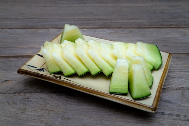 melon sliced on dish on wooden table