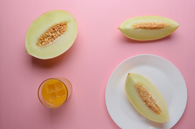 Melon sliced on pastel pink surface.