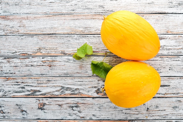 Melon Sliced to pieces of melon On a white wooden background Free space for text Top view