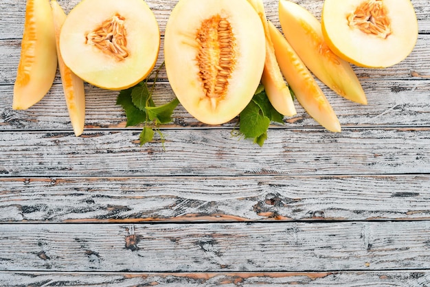 Melon Sliced to pieces of melon On a white wooden background Free space for text Top view