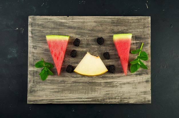 Melon, watermelon, blackberries and mint on a wooden table