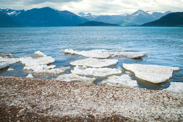 Melt the ice in the ocean on a background of mountains