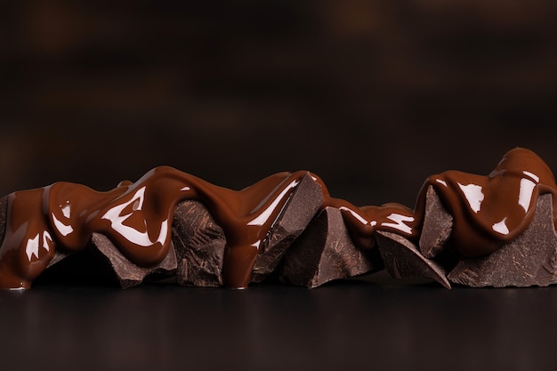 melted chocolate covers the pieces. delicious dessert on black table