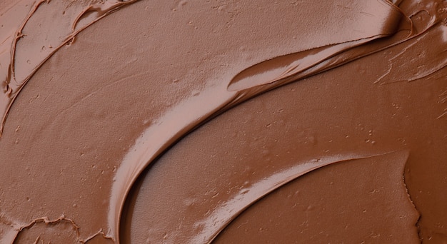 Melted chocolate cream  background, top view