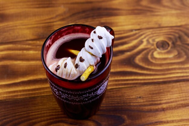 Photo melted marshmallow snowman in a cup of hot chocolate on wooden table