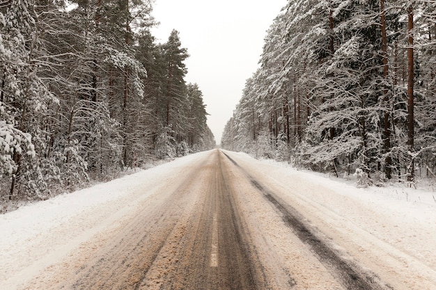 Melted snow on a car paved road