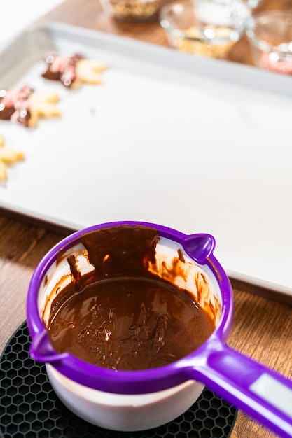 チョコレートをキャンディーポットに溶かしてクッキーを飾る準備