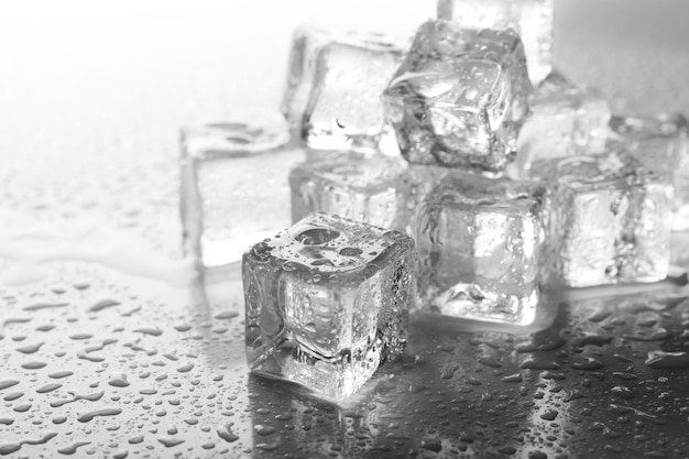 灰色の背景に溶ける氷の立方体を近づける