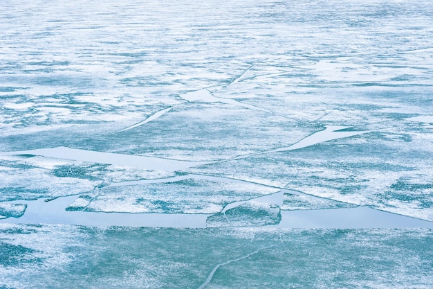 Melting ice on the frozen lake. Beautiful winter nature background