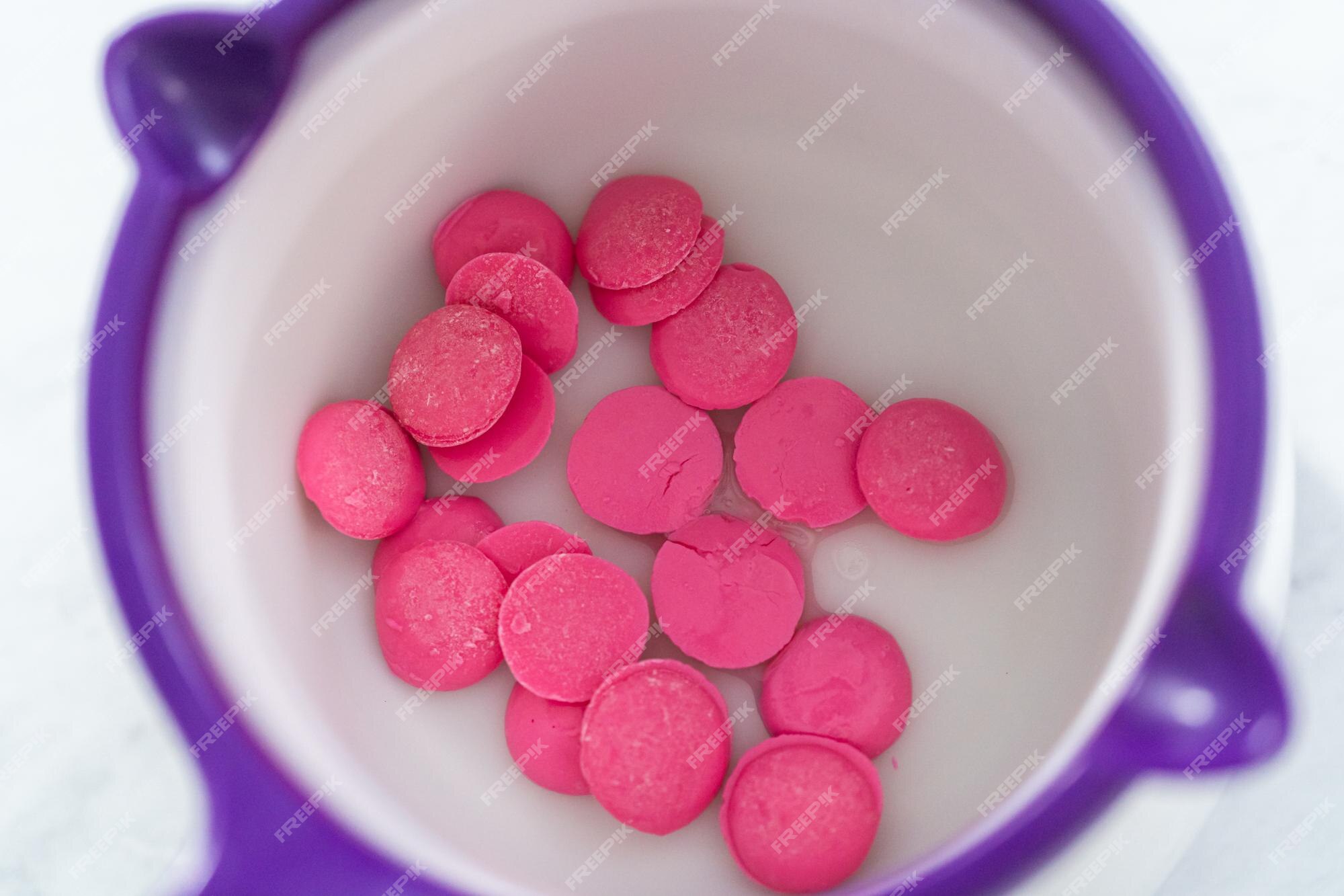 Premium Photo  Melting pink chocolate melts to make mini pink chocolates.