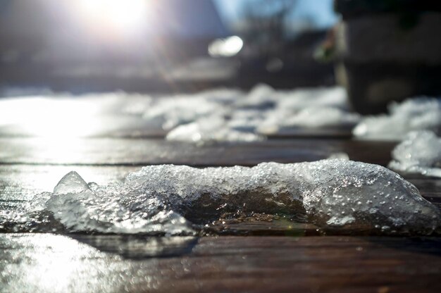 Melting snow on a wooden table in the warm