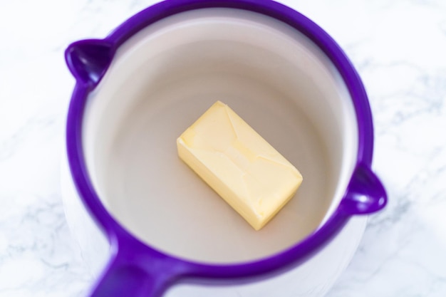 Melting stick of unsalted butter in candy melting pot