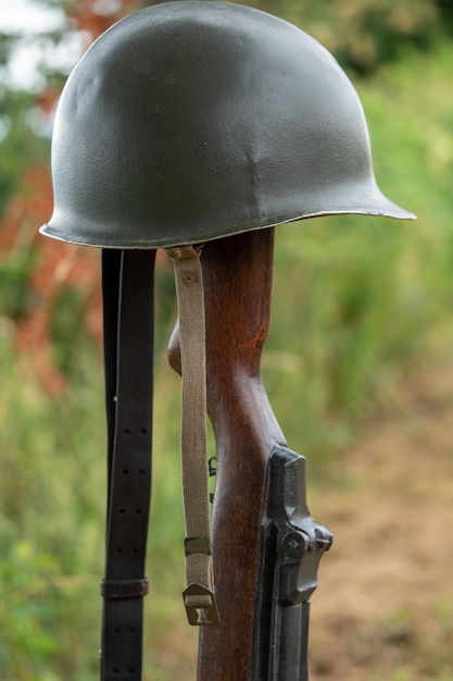 Memorial battlefield cross with the symbol of a fallen US soldier M1 rifle with helmet