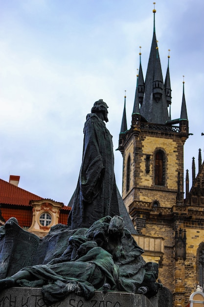 Memorial jan hus keek van achteren naar de toren van de Týn-kerk op een bewolkte dag in Praag.