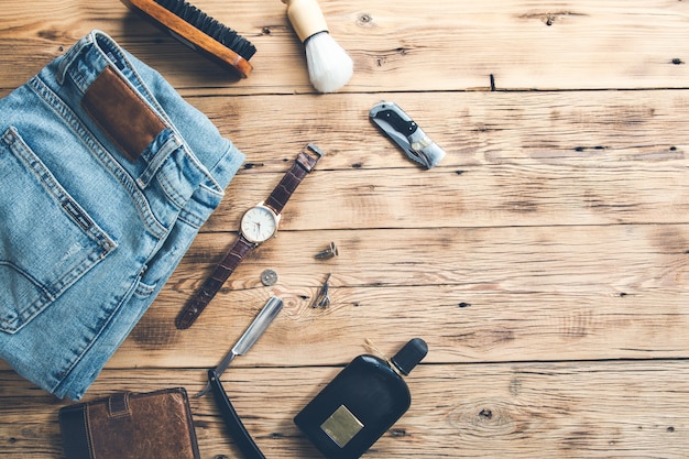 Men accessories with jeans and perfume on desk