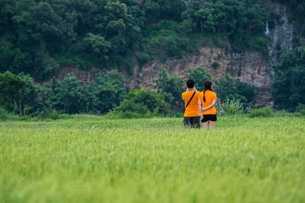 Фото Мужчины и женщины пары фотографируют на зеленом рисовом поле.