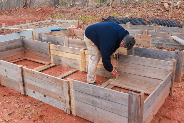 Photo the men are building new wooden frame for raised garden bed