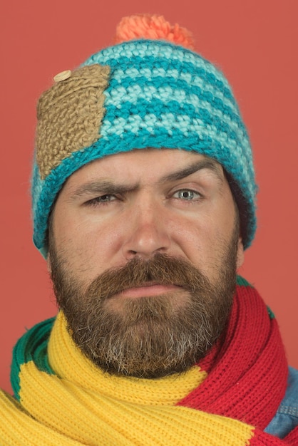 Men autumnwinter fashion serious man wiht beard wearing warm scarf wrapped around his neck hat on