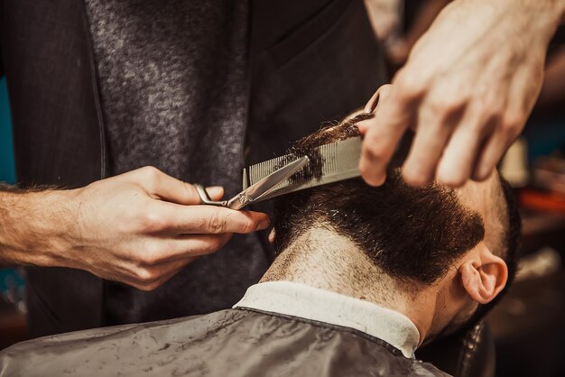 Men barber cuts the beard