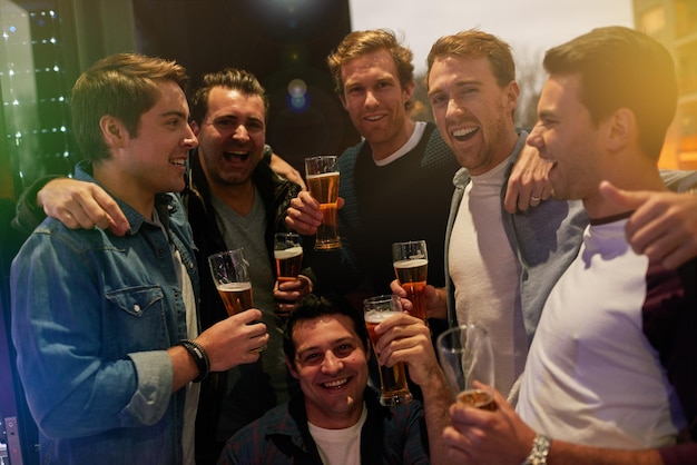 Men beers and cheers with friends drinking at club restaurant or party with happiness People alcohol and glasses at pub together for happy hour conversation or gathering for celebration