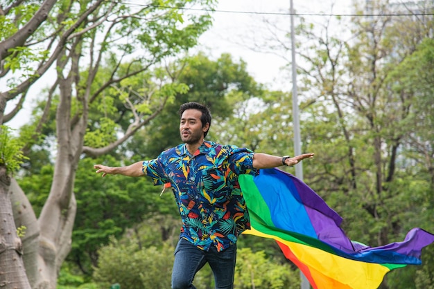 男性は LGBT の権利を促進するために肩に虹色の旗を運ぶlgbtq ライフ スタイル コンセプトlgbtq プライド月間