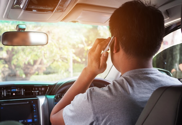 運転中の男性の携帯電話の使用