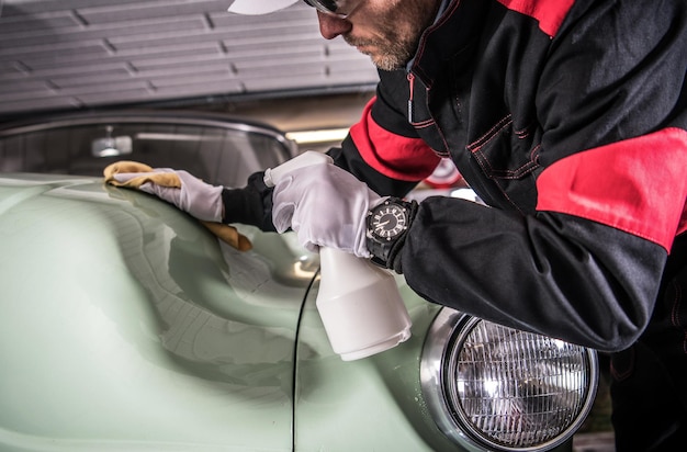 Foto uomini che puliscono la carrozzeria della sua macchina