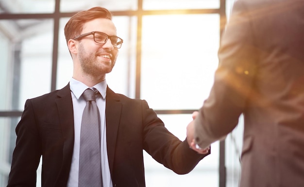 men colleagues in suits are meeting in office corridor