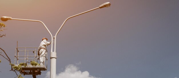 Men in cradle painting lamppost