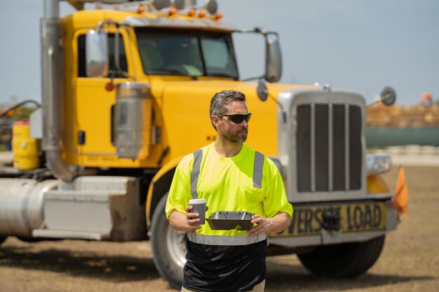 Photo men driver near lorry truck man owner truck driver in safety vest satisfied near truck millennial tr