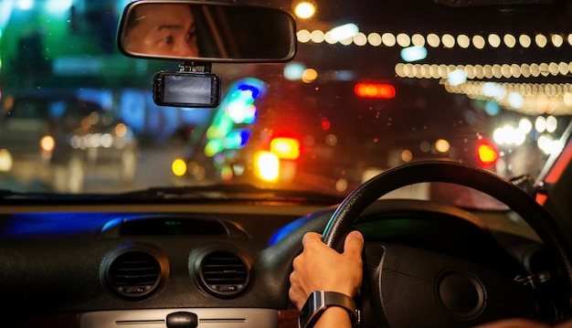 Men driving a car at night.