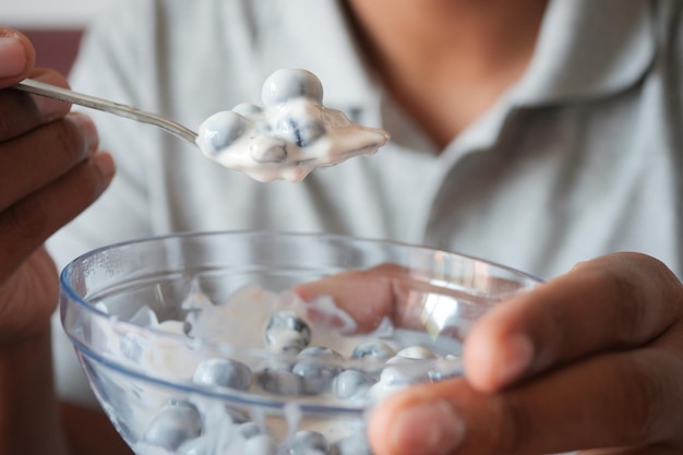 Men eating yogurt with blue berry in a bowl