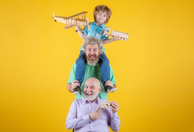 Men generation grandfather father and grandson are hugging looking at camera and smiling fathers day