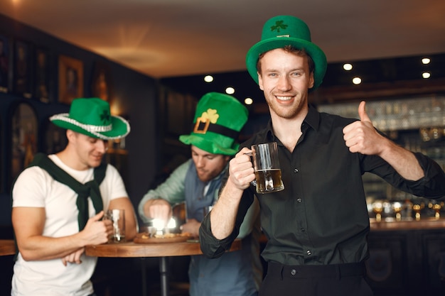 Uomini con cappelli verdi. gli amici celebrano il giorno di san patrizio. celebrazione in un pub.