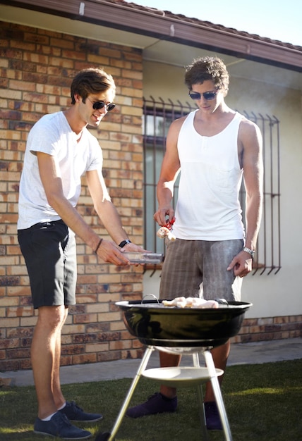 写真 男性のグリルと肉の季節は,裏庭でバーベキュー,料理,友達とのランチで,庭の食べ物,若い人たちと一緒に屋外でチャットし,庭でバーベキューのランチで食べる準備ができています