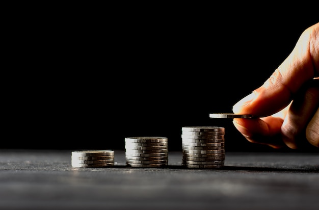 Men hand are sorted coins on a wooden board.