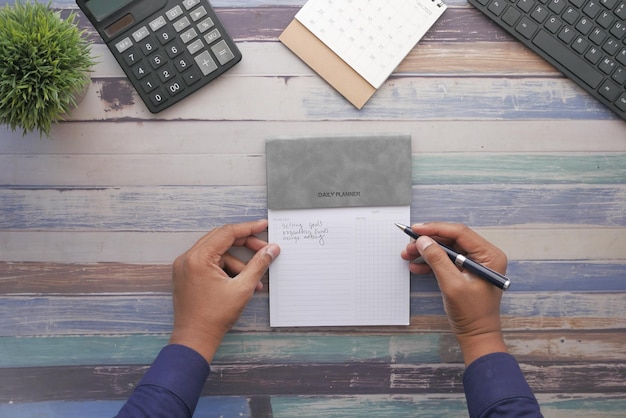 Men hand writing on a weekly planner