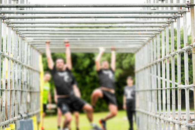 Photo men hanging on monkey bars at park during competition