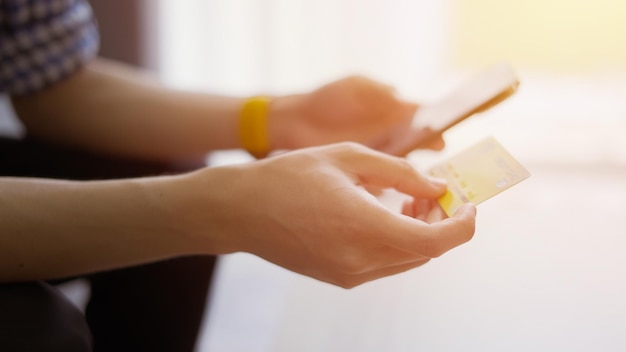 Men holding credit card and Shopping on smart phone at home