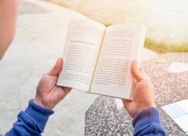 Men holding reading book on table,sunlight effect