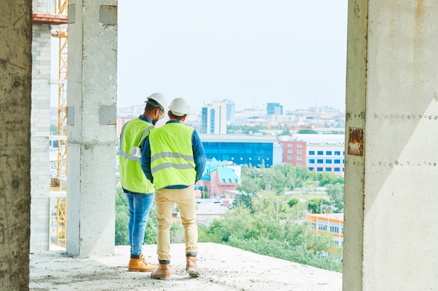 写真 マンションの建設現場でヘルメットの男性