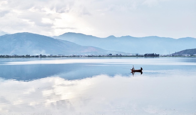 Foto uomini nel lago contro la catena montuosa