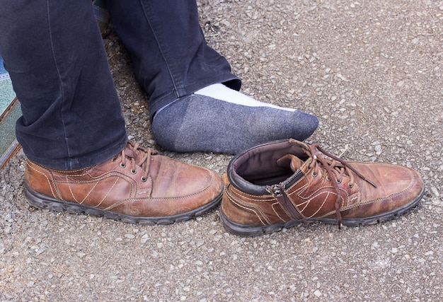 Men legs and old brown leather shoes