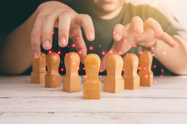 Photo men lining up wooden dolls in groups, business idea