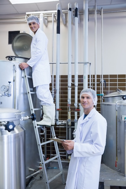 Men looking at the camera while on standing on the ladder